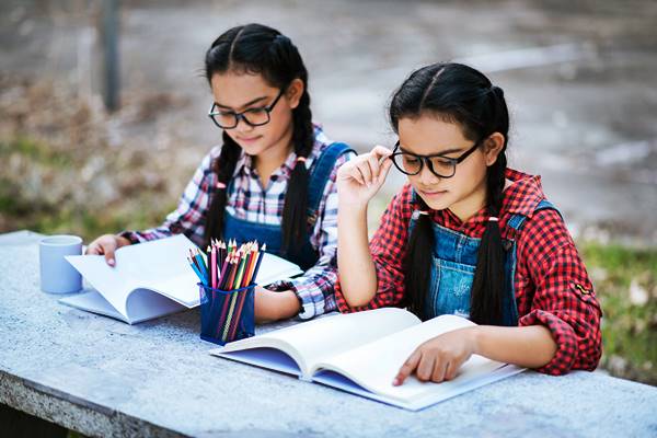 two girl child studying together at dwarka school ground