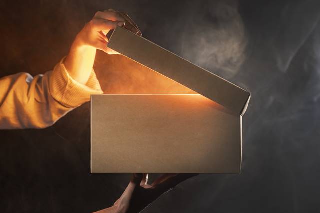 a box getting opened with yellow light coming out of it. 